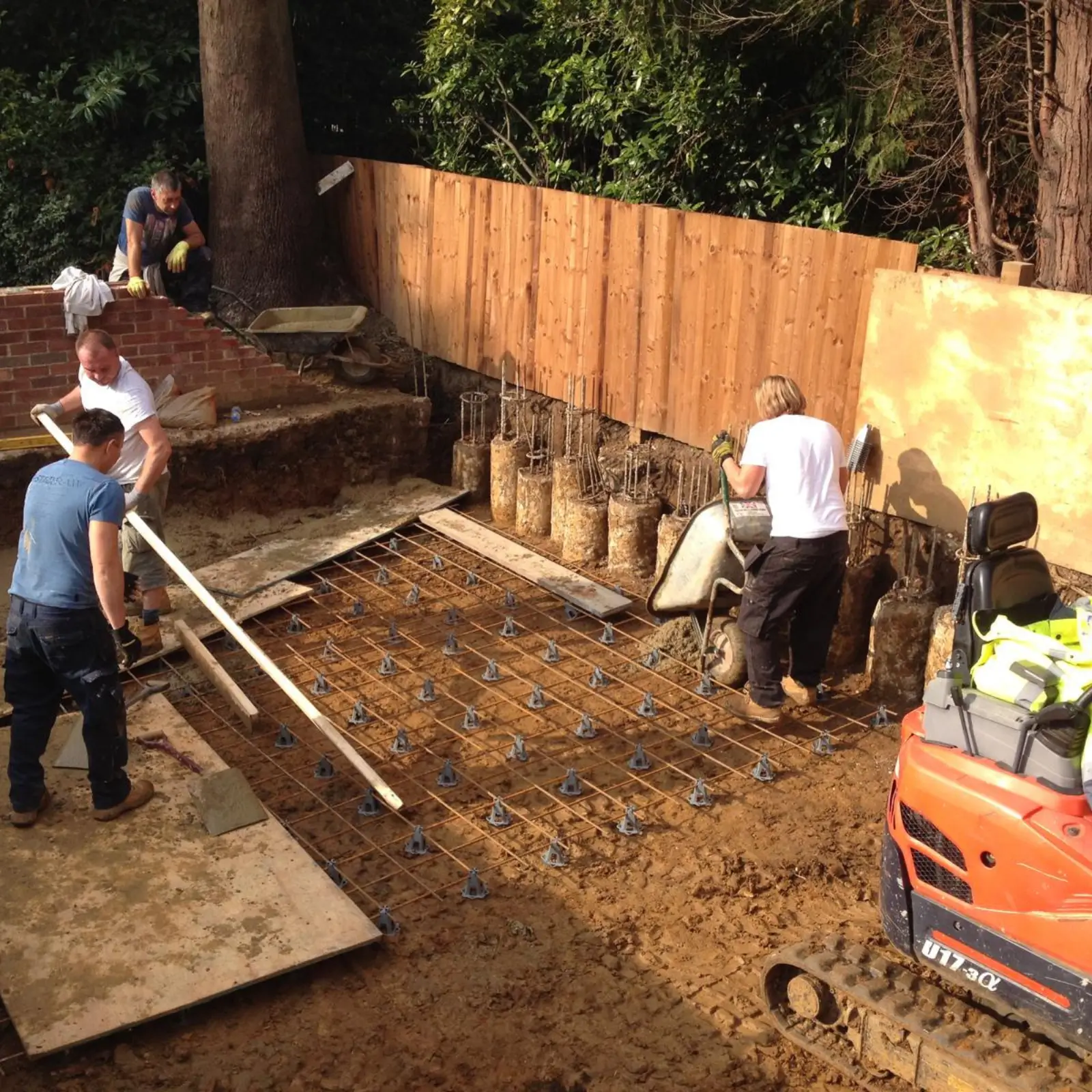 Workers install a rebar foundation with a mini piling rig.