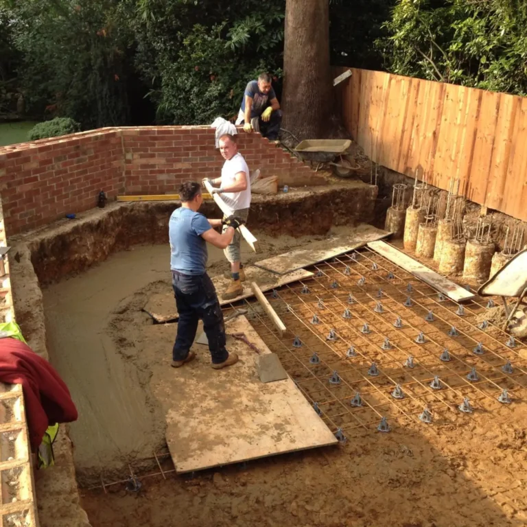 Construction crew laying groundwork and rebar for a foundation.