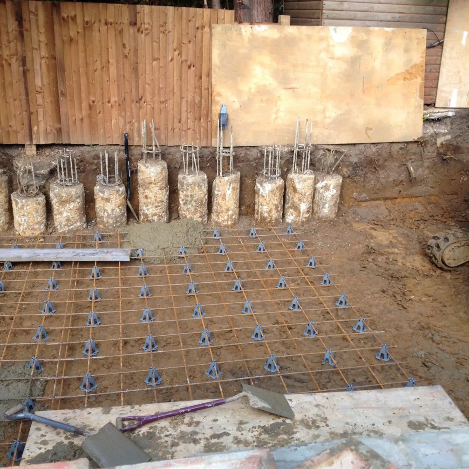 Rebar and concrete piles for a partial basement foundation.
