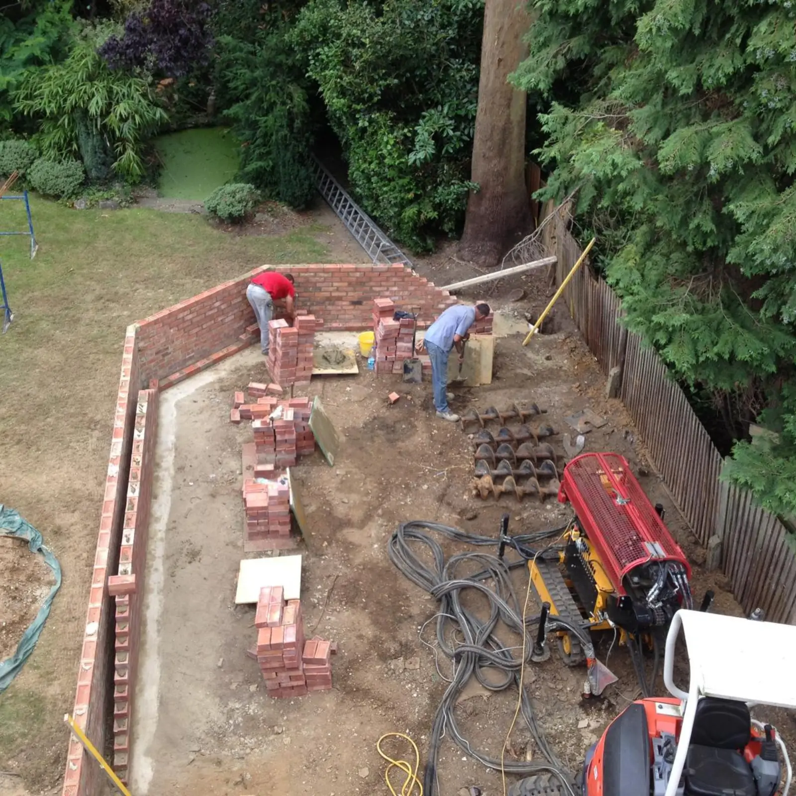 Workers building a brick wall as part of an underpinning project.