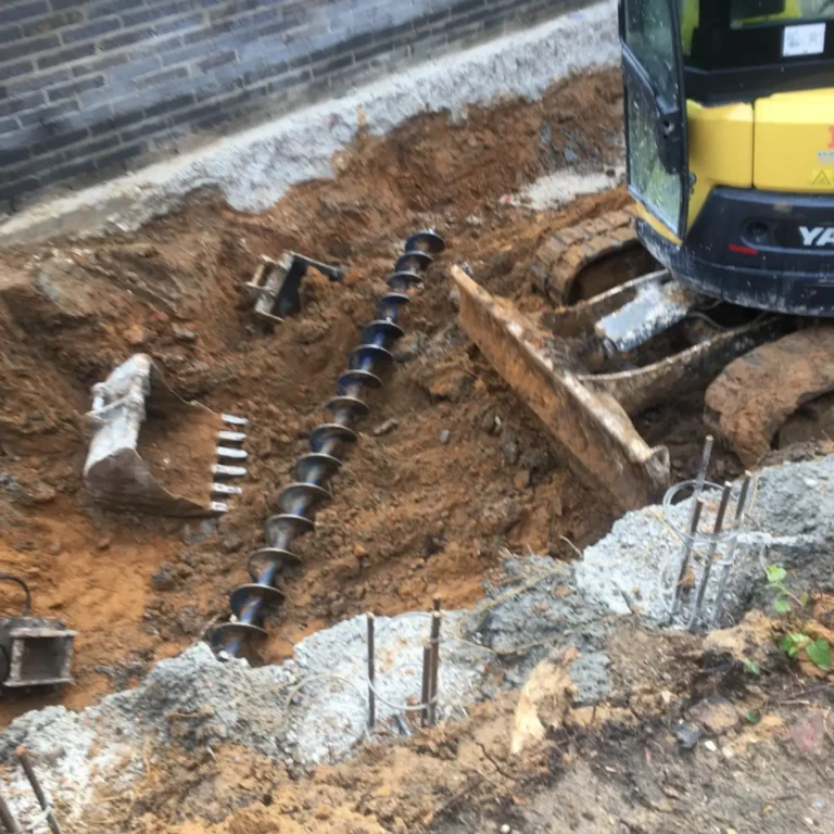 Goodman Mini Piling: Large piling auger on a construction site for foundation work.