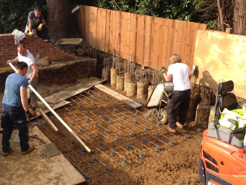 Workers install a rebar foundation with a mini piling rig.