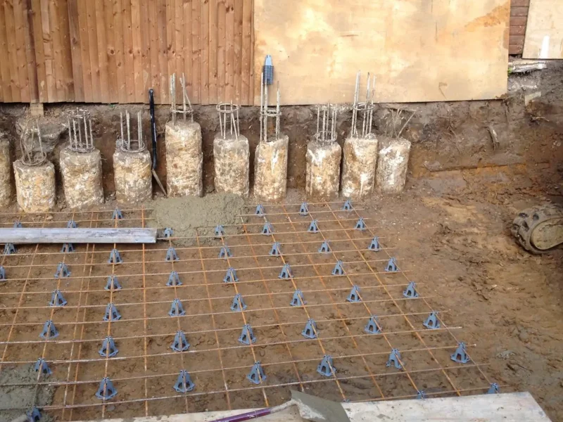 Rebar and concrete piles for a partial basement foundation.